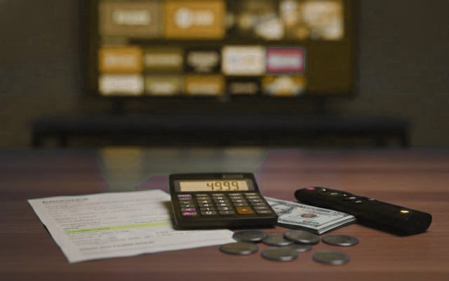 A calculator, US dollars and a streaming stick, showing how much an IPTV subscription costs per screen